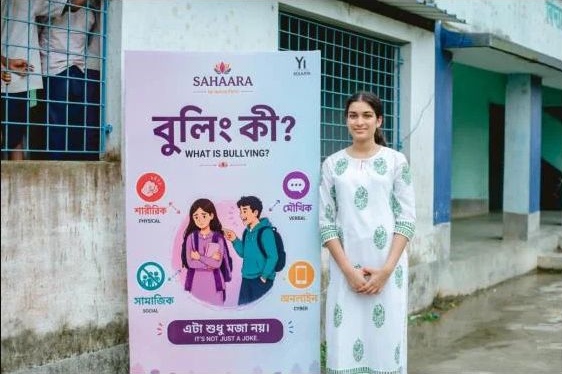 Aanya beside the Bengali bullying-awareness poster